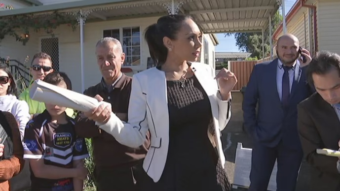 Female real estate agent conducting Sunday auction in Melbourne Victoria during competitive 3 week campaign